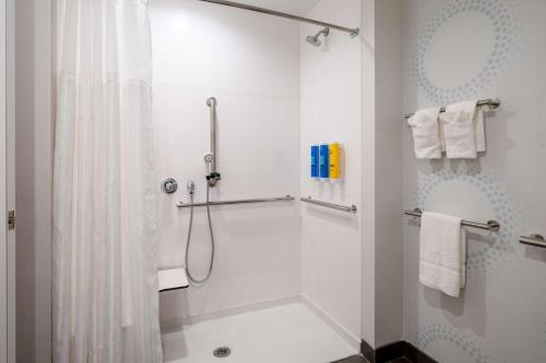 y baño con ducha y cortina de ducha. en Tru By Hilton Naperville Chicago en Naperville
