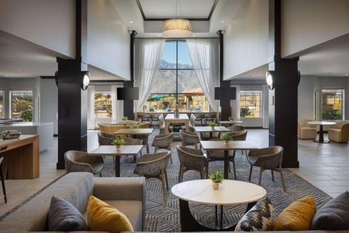 a hotel lobby with tables and couches and chairs at Homewood Suites by Hilton Cathedral City Palm Springs in Cathedral City