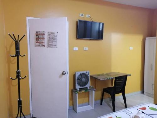 een kamer met een witte deur, een tafel en een televisie bij Stylus Hotel in Iquitos