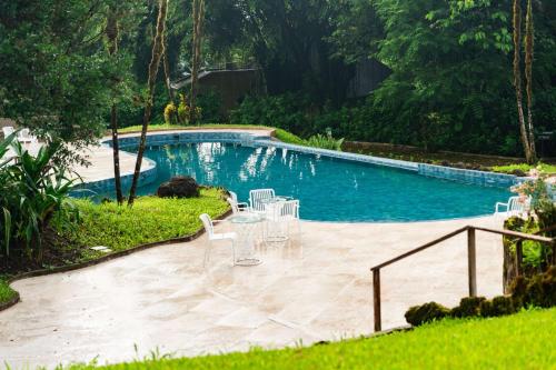a pool with chairs and a table in front of it at Royal Palm Galapagos, Curio Collection Hotel by Hilton in Bellavista