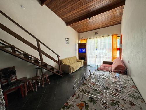 Una sala de estar con una escalera y un sofá. en Caraguá Sol e Mar 1, en Caraguatatuba