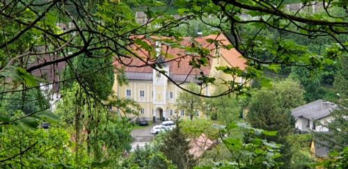 a yellow house with a red roof in a city at Turmhaus Trieben Wohnung 2 in Trieben