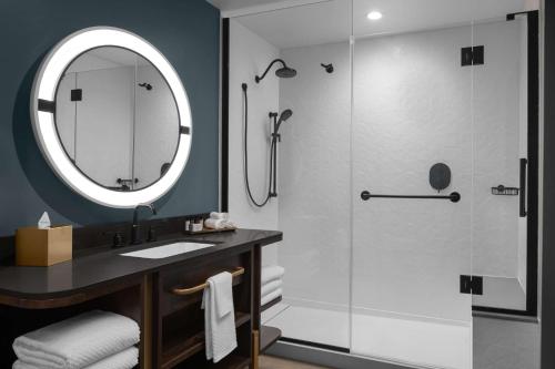 a bathroom with a shower with a sink and a mirror at Hotel West & Main Conshohocken, Tapestry Collection Hilton in Conshohocken