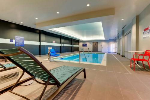 una piscina con una silla y una piscina en Tru By Hilton Smithfield I-95, en Smithfield