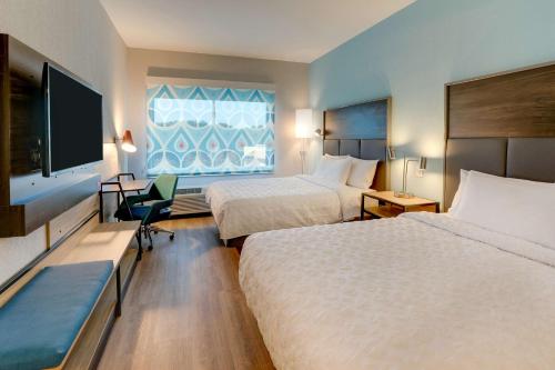 a hotel room with two beds and a flat screen tv at Tru By Hilton Smithfield I-95 in Smithfield