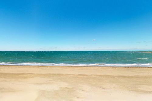 an empty beach with the ocean in the background at Seabreeze Serenity in Scituate