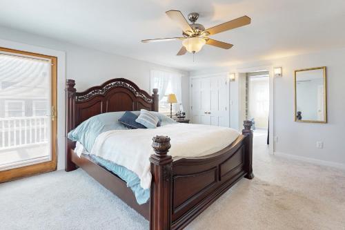 a bedroom with a large bed with a ceiling fan at Seabreeze Serenity in Scituate