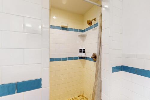 a bathroom with a shower with blue and white tiles at Seabreeze Serenity in Scituate