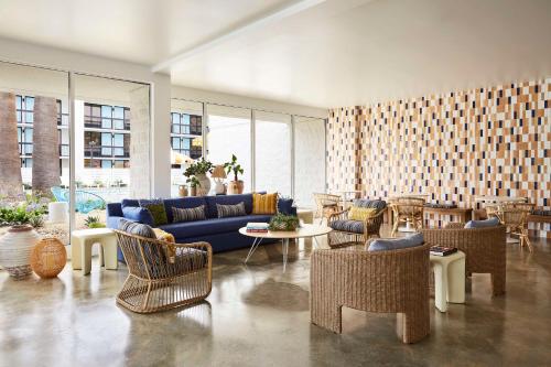 a living room with a blue couch and chairs at Avatar Hotel Santa Clara, Tapestry Collection by Hilton in Santa Clara