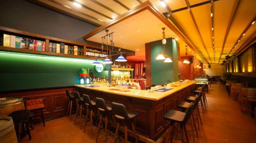 a bar in a restaurant with a long counter and chairs at Nova Vista Centrum Hotel Eskisehir, a Member of Radisson Individuals in Eskisehir