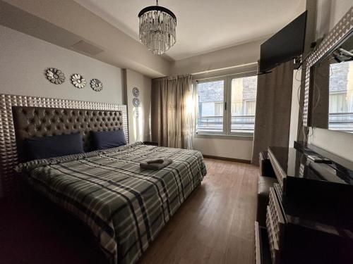 a bedroom with a bed and a television and a chandelier at Mirage residence resort in Cairo