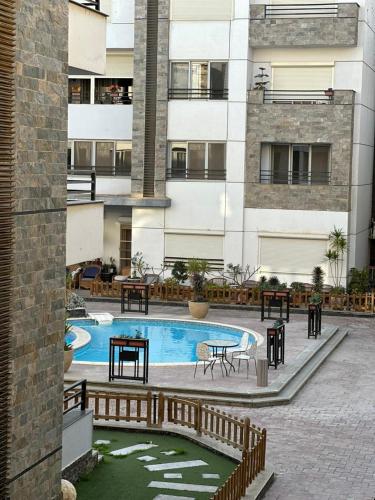 a courtyard with a pool and tables and a building at Mirage residence resort in Cairo
