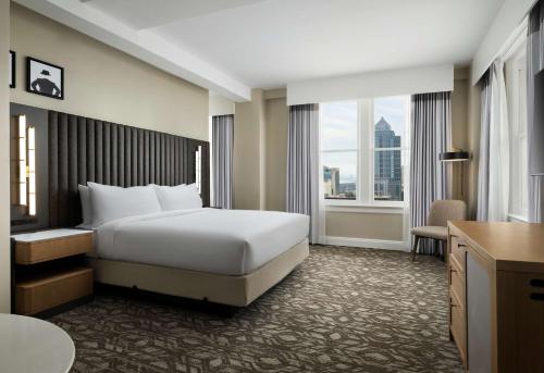 ein Hotelzimmer mit einem Bett und einem großen Fenster in der Unterkunft Hotel Flor Tampa Downtown, Tapestry Collection By Hilton in Tampa