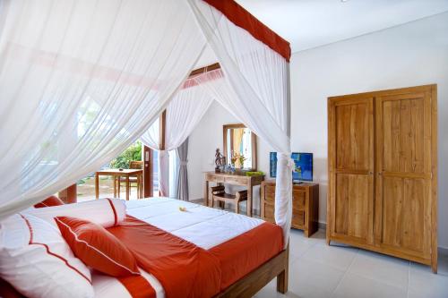 a bedroom with a canopy bed and a desk at Villa Yenian in Canggu