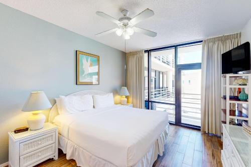 Un dormitorio con una cama blanca y una ventana. en Sunchase IV #327, en South Padre Island