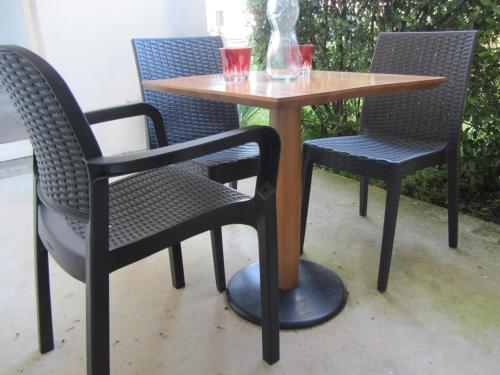 - une table avec deux chaises et une table avec deux verres dans l'établissement T2 36 m2 Près du lac, Parc 55 hectares accessible à pied !, à Bergerac