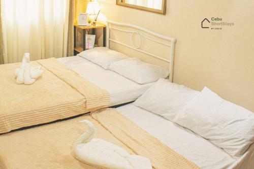 duas camas num quarto com toalhas em Cozy Studio Unit at Persimmon em Cebu