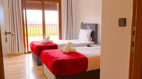 2 camas en una habitación con ventana en Imran Appart Tanger, en Tánger