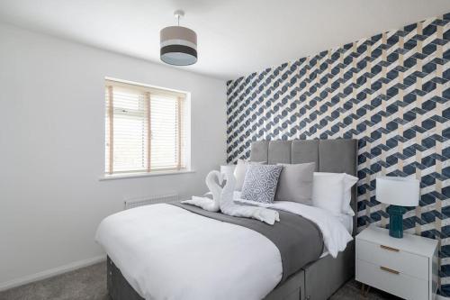 a bedroom with a bed with a blue and white patterned wall at Last min discount - Spacious 3b - Essentials near in Woolstone