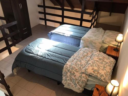a bedroom with two beds with blue sheets at Departamentos El Amanecer in Centenario
