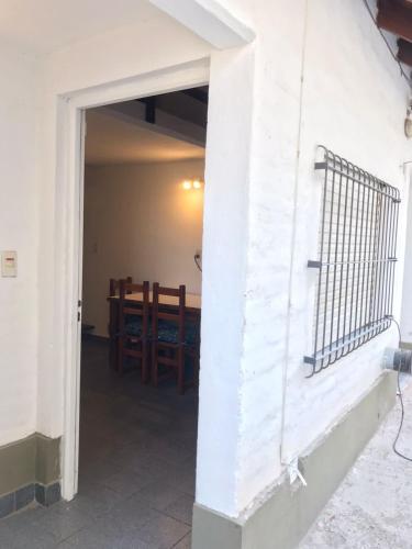 an open door to a dining room with a fence at Departamentos El Amanecer in Centenario