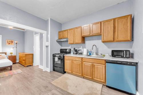 a kitchen with wooden cabinets and a sink and a stove at Historic Cozy Haven in Little Italy in Cleveland
