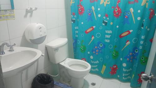 a bathroom with a toilet and a shower curtain at HOTEL VISTA AL MAR habitacion para 2 personas in Rodadero