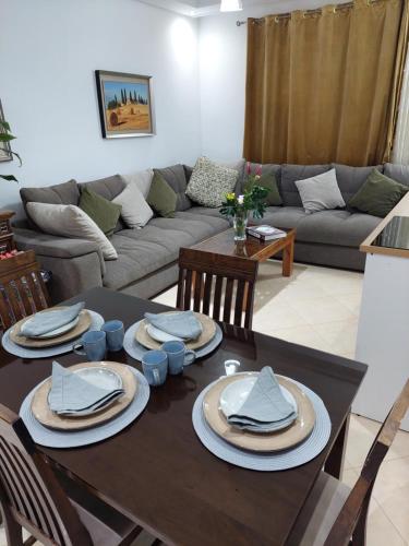 a living room with a table and a couch at Chabili Appartements in Temara