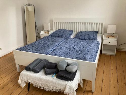 1 dormitorio con 1 cama blanca con sábanas azules y espejo en *-Sustainable Living/S-Home/SchälSick/Haus Frieda en Bonn