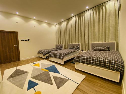 Zimmer mit 2 Betten und einem Teppich in der Unterkunft أستراحة أريـــان in Gharayfah