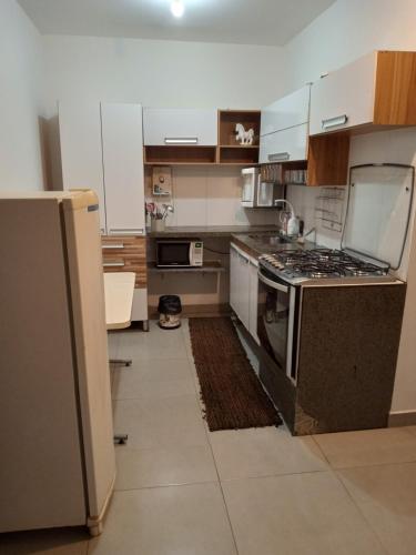 a kitchen with a stove and a refrigerator at casa com bela vista em itatiba in Bragança Paulista