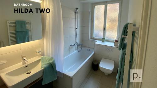 łazienka z wanną, toaletą i umywalką w obiekcie H2 with 3,5 rooms, 2BR, living room and kitchen, central and quite w Zurychu