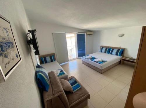 a living room with a bed and a couch at Apartmani ARIANA in Dobra Voda