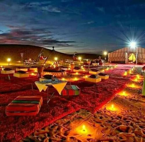 a group of umbrellas on a beach at night at Merzouga Luxurious Camp in Merzouga