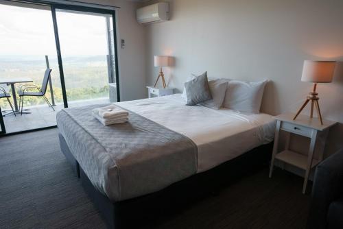 a bedroom with a large bed and a large window at Tranquil Park in Maleny