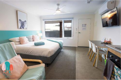 a living room with a bed and a table at Botanic City Apartments in Warrnambool