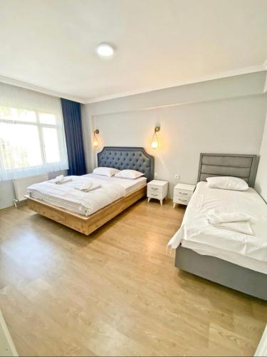 two beds in a large room with wooden floors at SULTANAHMET ROYAL APART in Istanbul