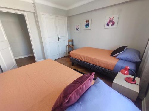 Habitación pequeña con 2 camas y ventana en Mahatma Hostel, en Santiago