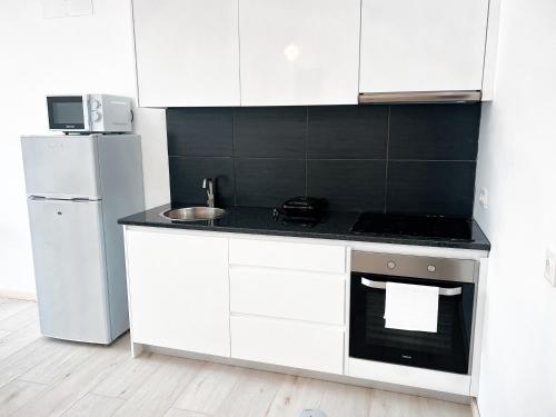 a white kitchen with a stove and a refrigerator at P&SApartments in Santa Maria
