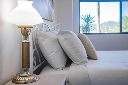 a bedroom with a bed with pillows and a lamp at Day Dreaming - Mazlin House in Airlie Beach