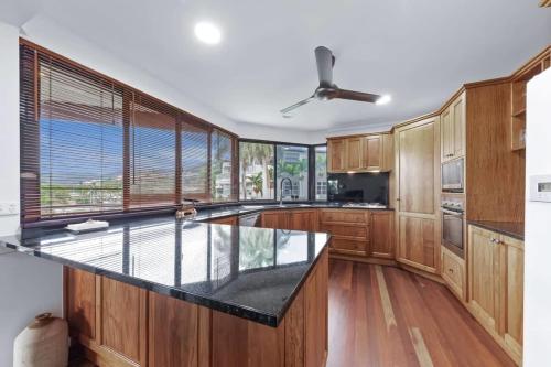a kitchen with wooden cabinets and a large window at Day Dreaming - Mazlin House in Airlie Beach