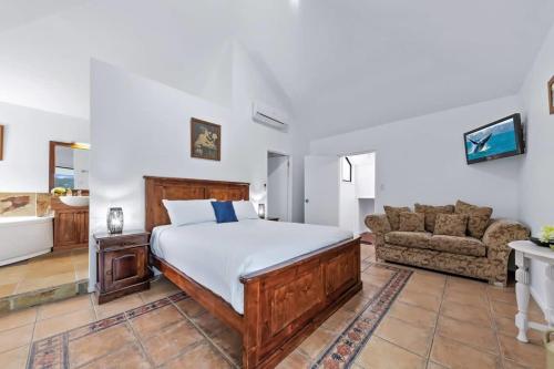 a bedroom with a bed and a couch at Day Dreaming - Mazlin House in Airlie Beach