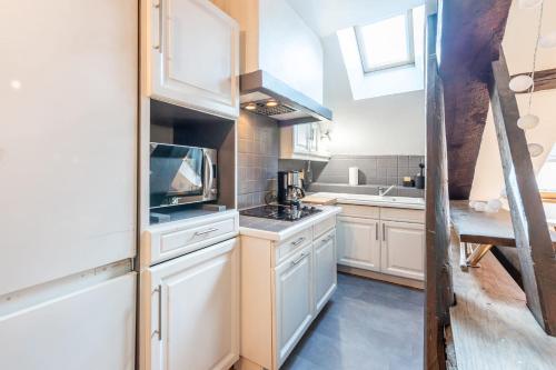 une cuisine avec des armoires blanches et un évier dans l'établissement LE PAQUIER T3 - à deux pas du lac, à Annecy