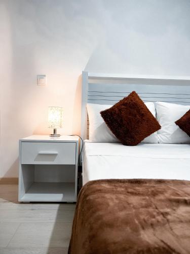a bedroom with two beds and a night stand with a lamp at P&SApartments in Santa Maria