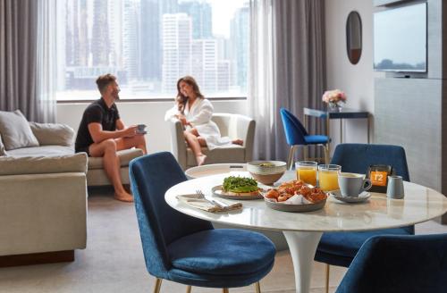 Una sala de estar con una mesa con un plato de comida. en Crowne Plaza Melbourne by IHG, en Melbourne