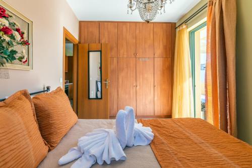 a bedroom with a bed with a stuffed animal on it at Fantasia double apartments by the sea Rethymno in Rethymno Town