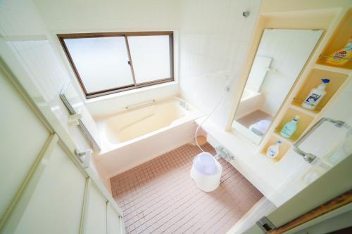 vista sul soffitto di un bagno con vasca e finestra di 貸切民泊勝山ベース325 福井県立恐竜博物館まで車で5分 