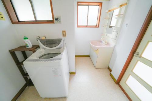 a washing machine in a bathroom with a sink at 貸切民泊勝山ベース325 福井県立恐竜博物館まで車で5分 in Kitarokuroshi