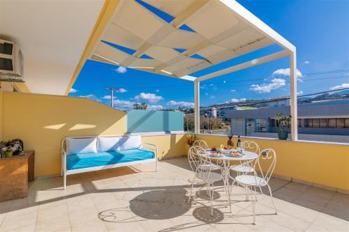 a patio with a table and chairs on a balcony at Fantasia double apartments by the sea Rethymno in Rethymno Town