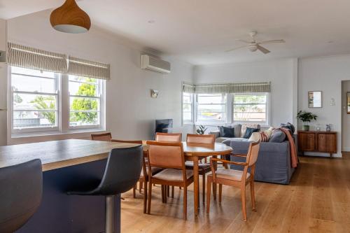 a kitchen and living room with a table and chairs at Sussex Beach House in Sussex inlet